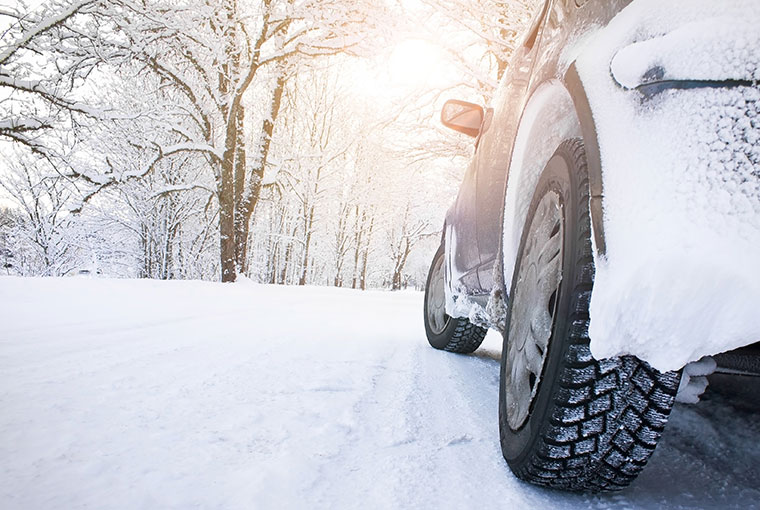 car tires on witer road in snowy morning